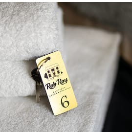 A hotel key tag resting on a neatly folded towel